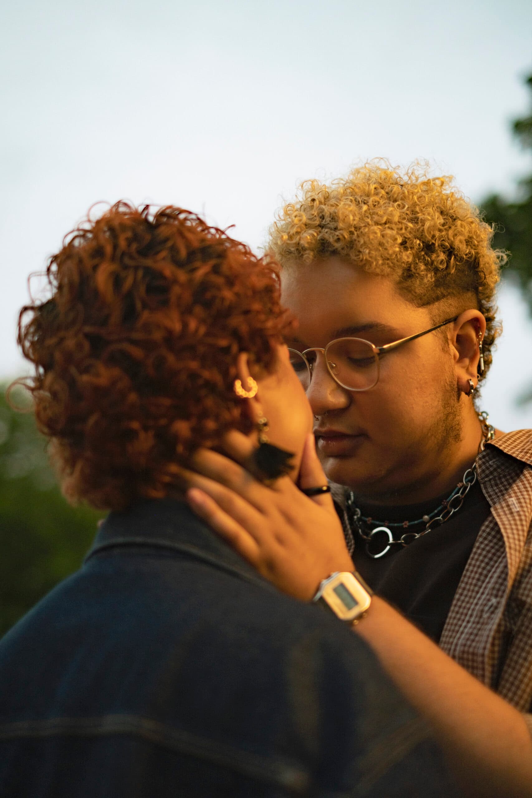 A trans couple embracing outside at dusk