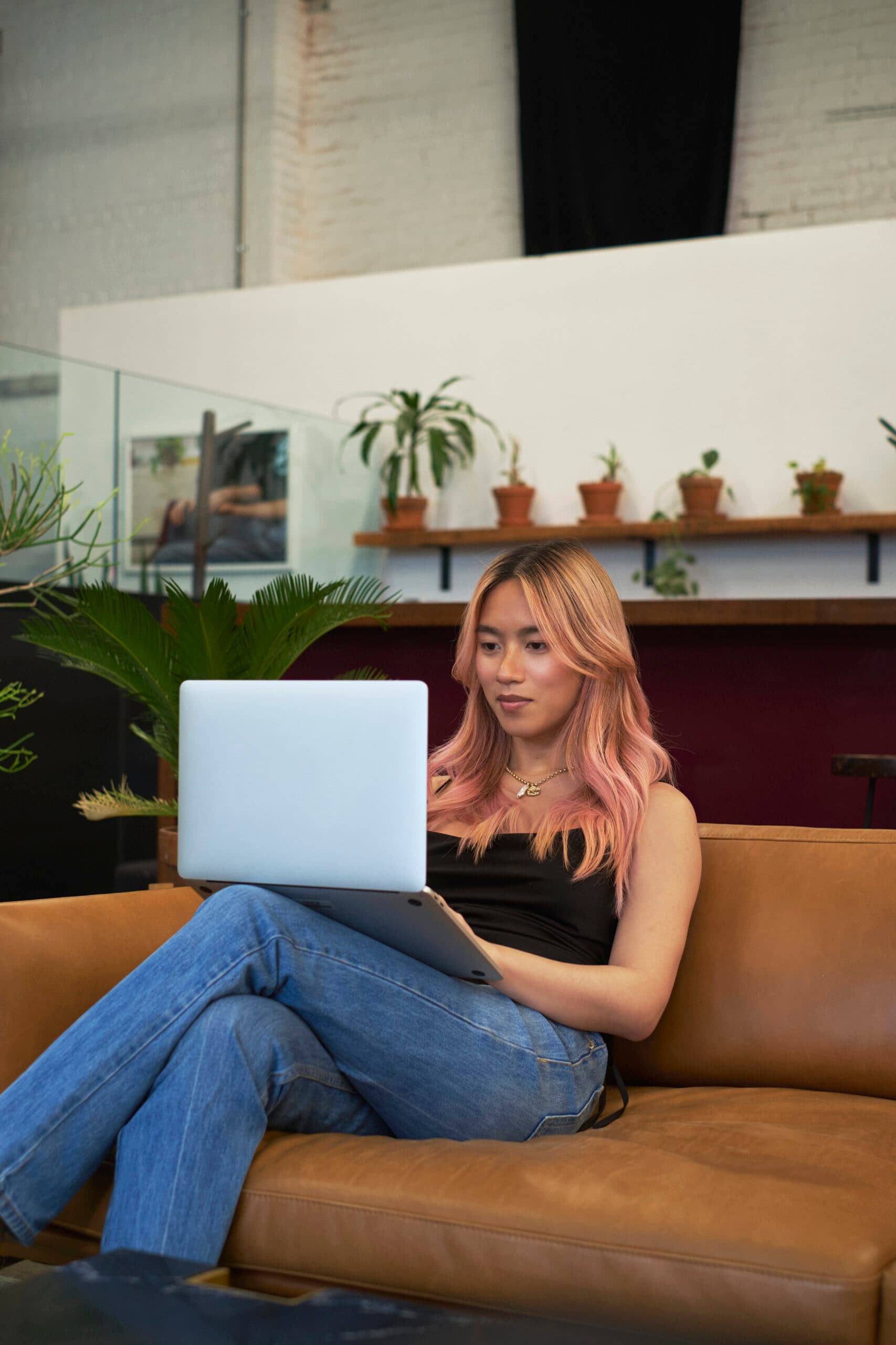 A transfeminine person using a laptop at work